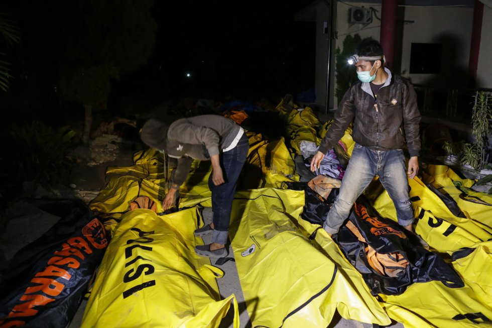 Varios hombres controlan los cuerpos de las vÃ­ctimas del terremoto y el tsunami mientras buscan a sus familiares en un hospital de la policÃ­a en Palu, el 29 de septiembre.