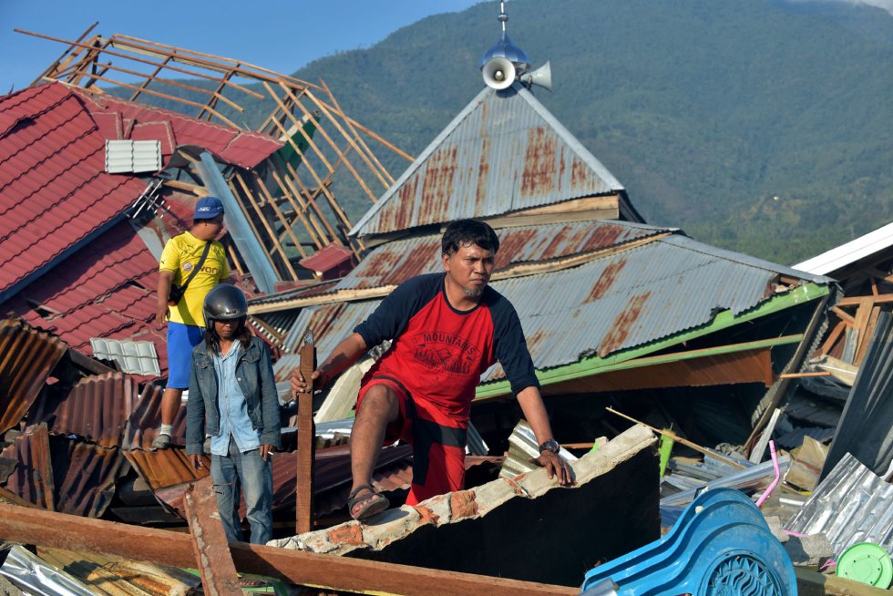 Personas entre los escombros de las casas derribadas en Palu por el azote del terremoto y el tsunami del 28 de septiembre.