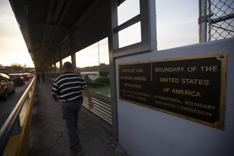 Un hombre cruza el puente que une México con Estados Unidos.