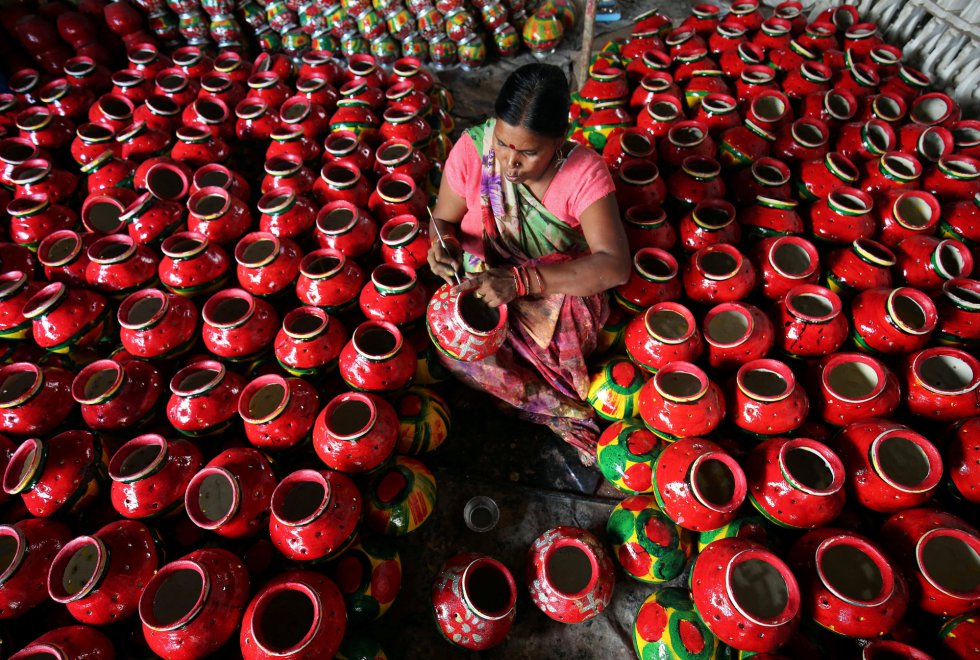 Una mujer decora cántaros de barro típicos de Garba, una danza folclórica india, para el festival hindú de Navratri (India).