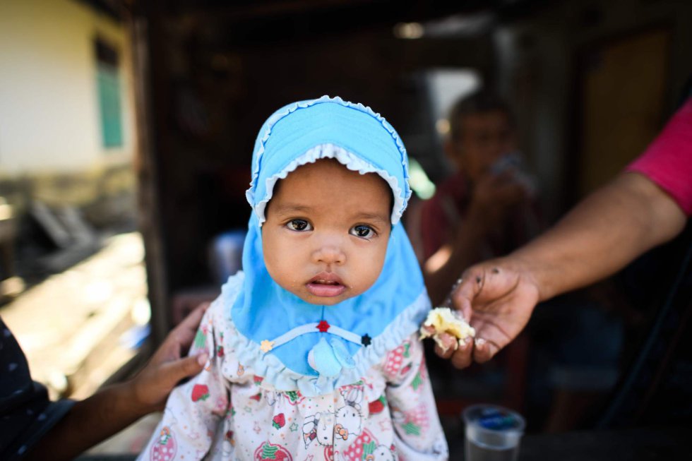 Una niña recibe alimento en un centro de Sulawesi (Indonesia).