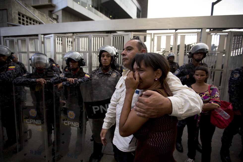 Miembros del equipo del concejal Alberto Albán se abrazan a las afueras de la sede del Servicio Bolivariano de Inteligencia Nacional (SEBIN) en Caracas (Venezuela), el 8 de ocstubre de 2018, tras conocer la muerte del concejal opositor.