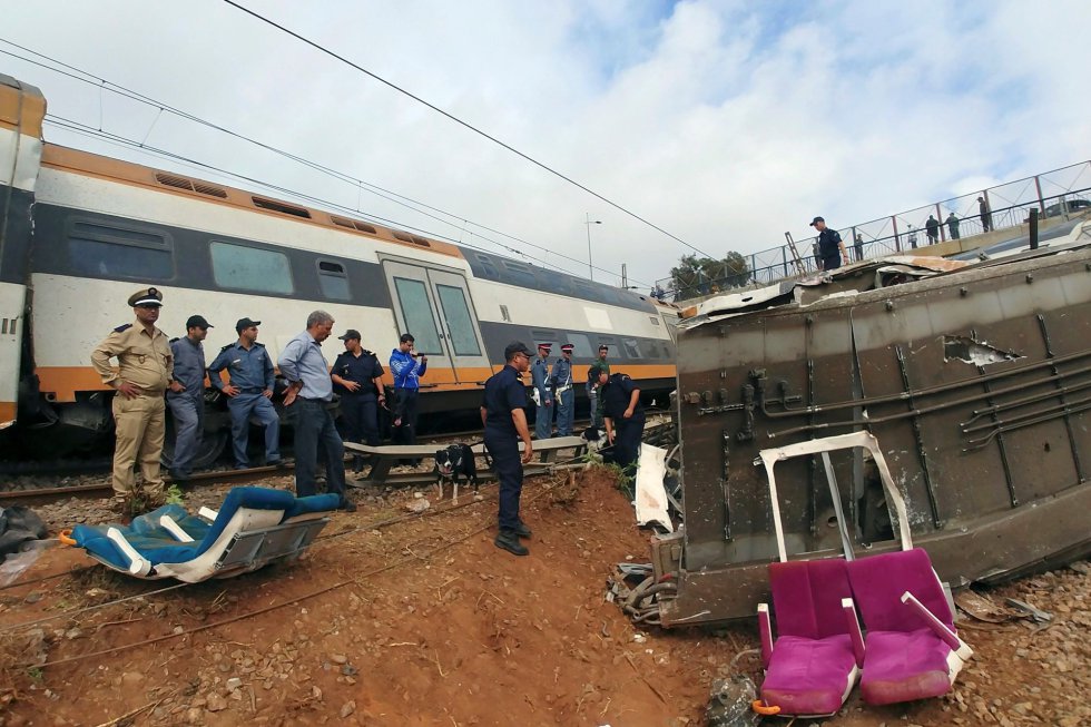 Varios asientos dañados de uno de los vagones, se ven en el exterior junto al tren descarrilado.