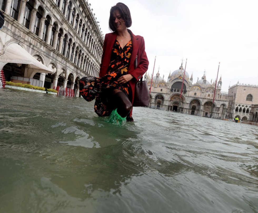 Una turista pasea por una inundada plaza de San Marcos en Venecia.