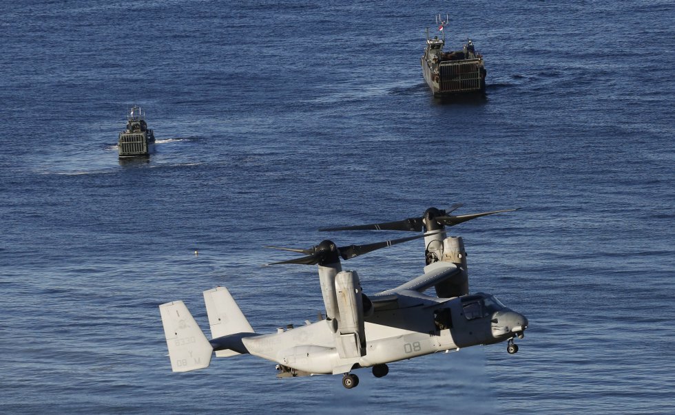 Vista de un helicÃ³ptero de combate y dos embarcaciones durante las maniobras.
