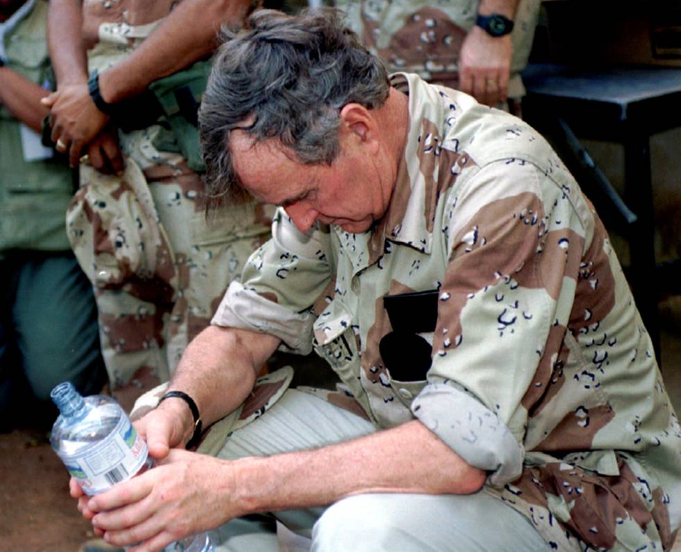 El entonces presidente de EE UU, George H. W. Bush, descansa con una botella de agua entre sus manos durante una visita en enero de 1993 a las tropas estadounidenses desplegadas en Somalia.