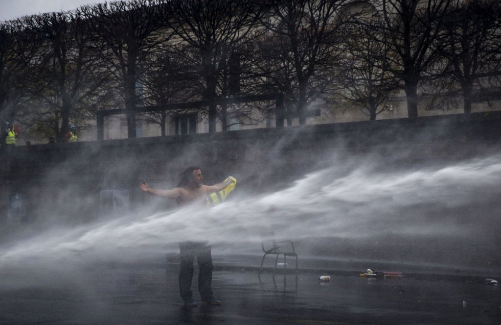 Un manifestante recibe el impacto de un cañón de agua de la policía durante los disturbios en París.