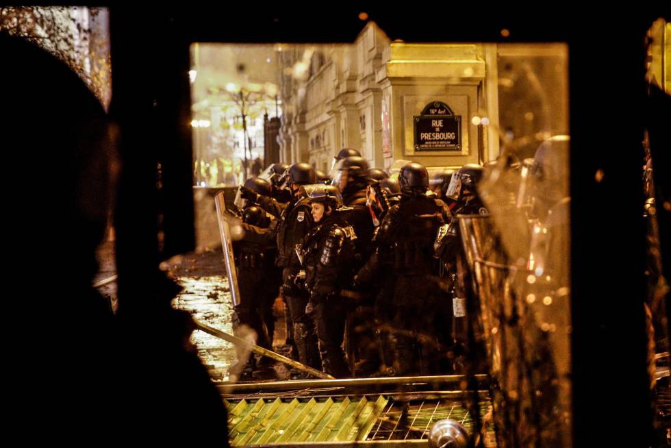 Agentes de la policía junto a un restaurante saqueado en las protestas de este sábado en el centro de la capital francesa.