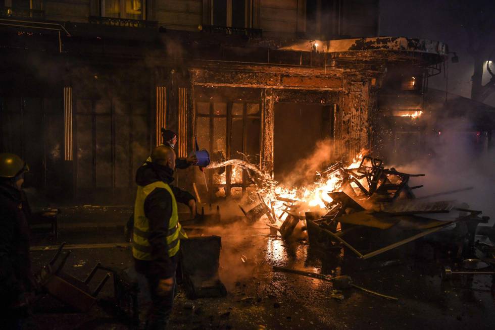 Un manifestante intenta apagar el fuego de una de las barricadas levantadas en una calle parisiense.