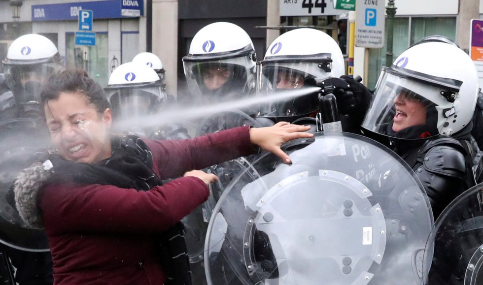 Una agente antidisturbios rocía a una mujer con gases lacrimógenos durante la protesta de 'chalecos amarillos'en Bruselas (Bélgica), el 8 de diciembre.