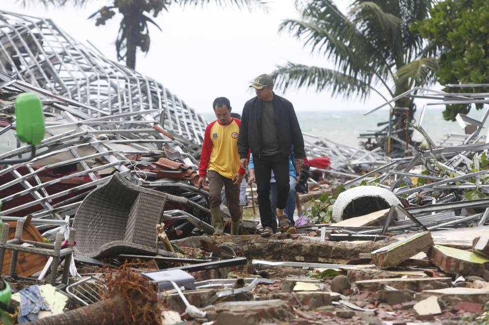 Dos hombres caminan entre los escombros en Pandeglang (Indonesia), azotado por un tsunami. "Muchos niños están enfermos, tienen fiebre, dolor de cabeza y no tienen suficiente agua", explicó Rizal Alimin, un médico de la ONG Aksi Cepat Tanggap, en una escuela transformada en refugio improvisado.