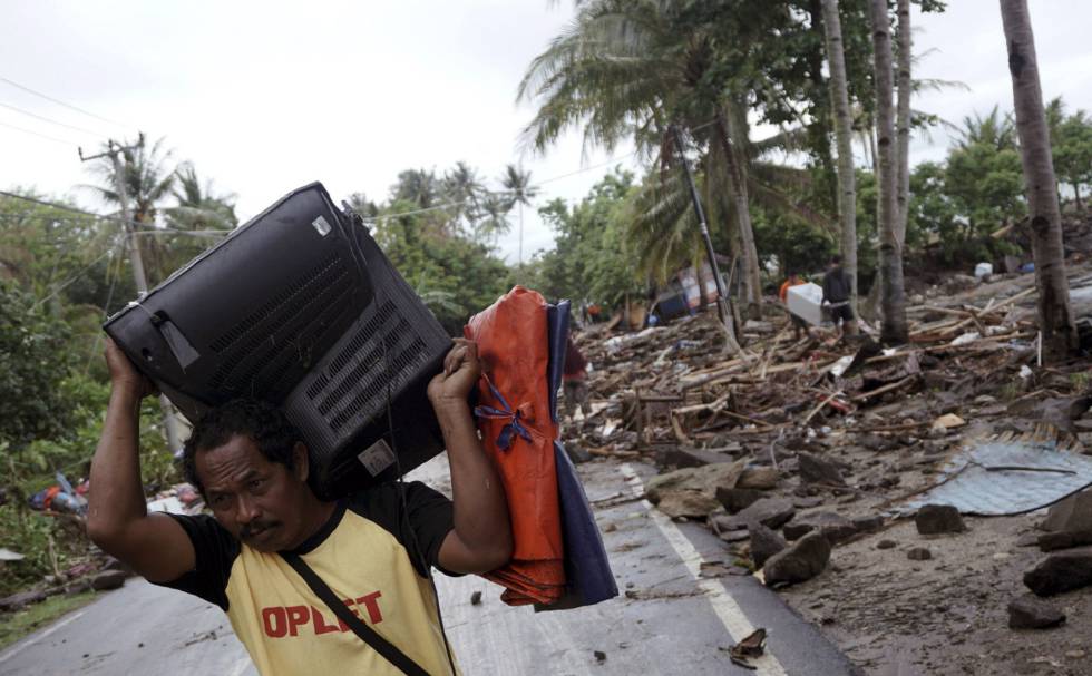 Un hombre salva su televisión después de que un tsunami sacudiera Anyer (Indonesia) el pasado sábado..
