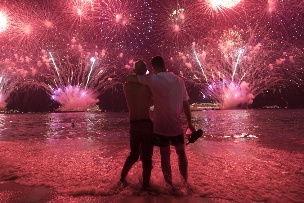 Dos hombres observan los fuegos artificiales desde la playa de Copacabana de RÃ­o de Janeiro (Brasil).