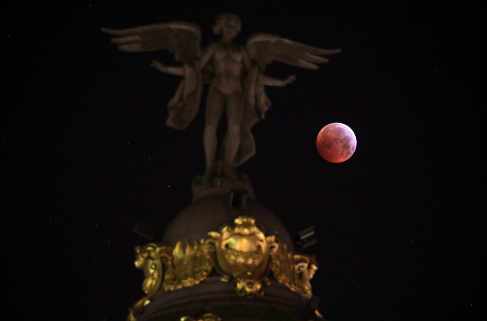 A superlua de sangue vista ao lado da estátua do 'Victoria Alada' em Madri (Espanha).