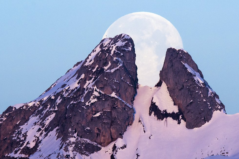 La Luna es vista entre las montaÃ±as Les Jumelles de Plambuit (Suiza).