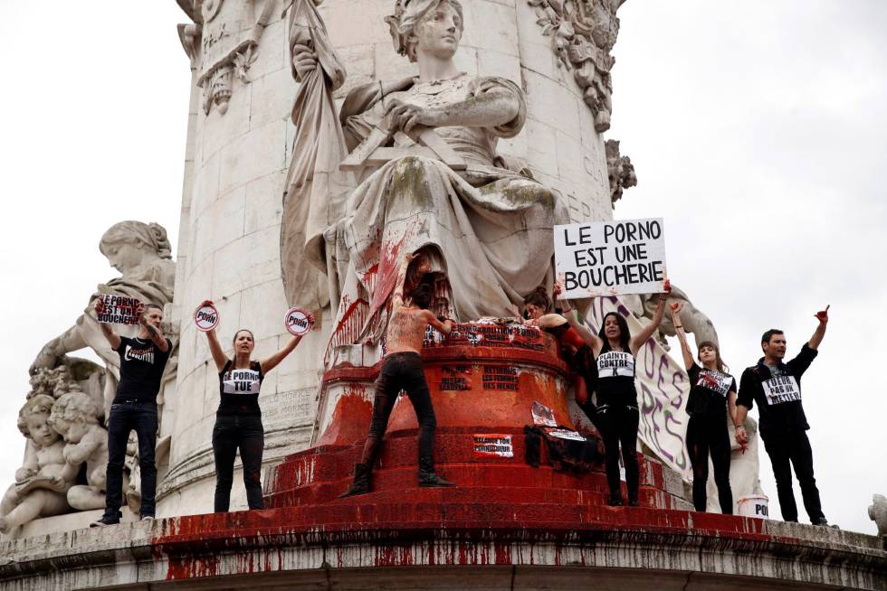 Activistas en contra de la pornografía derraman sangre falsa sobre la estatua de la Plaza de la República durante una marcha con motivo del Día Internacional de la Mujer este viernes en París, Francia. Los activistas mostraron pancartas con mensajes como