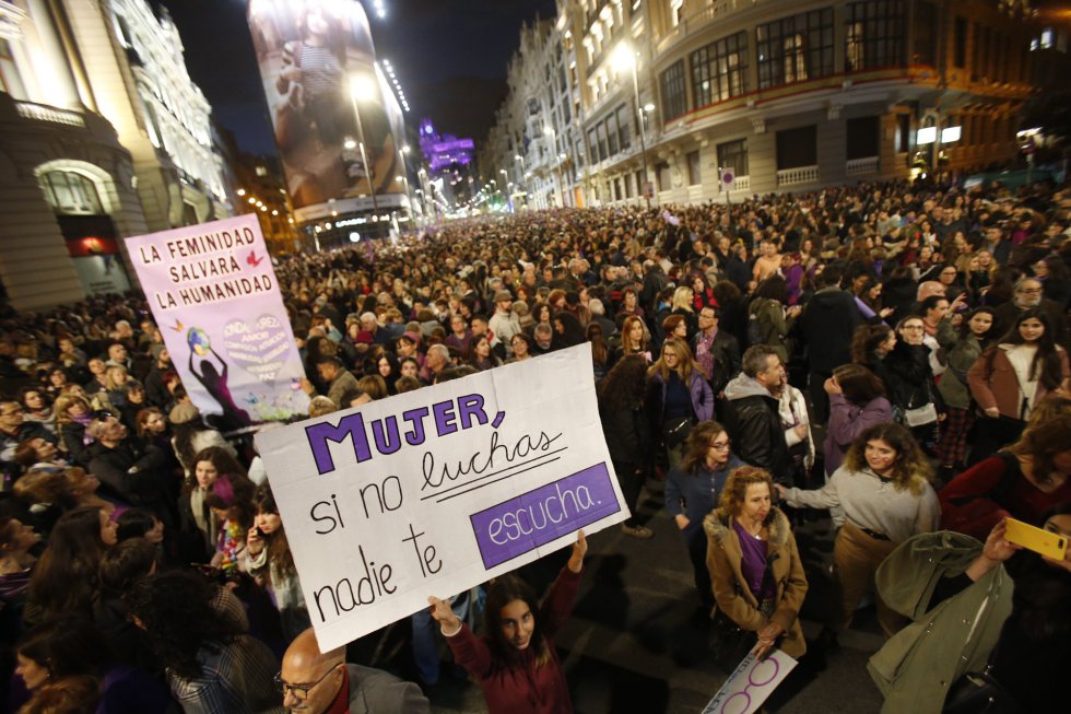 Una mujer sostiene un cartel donde puede leerse 'Mujer si no luchas nadie te escucha', durante la manifestación de Madris a su paso por la Gran Vía.