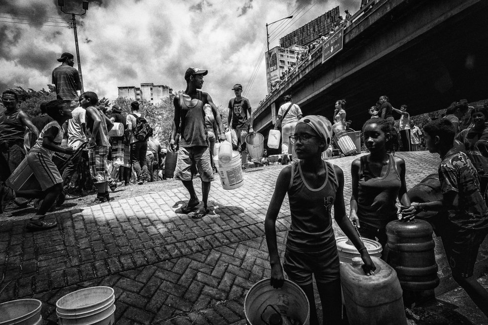 Vecinos del barrio San Martín (Caracas)  son replegados por la Policía Nacional Bolivariana tras recolectar agua de un riachuelo natural en la ciudad de Caracas durante los apagones que han provocado una fuerte crisis de suministros, el 13 de marzo de 2019.rn