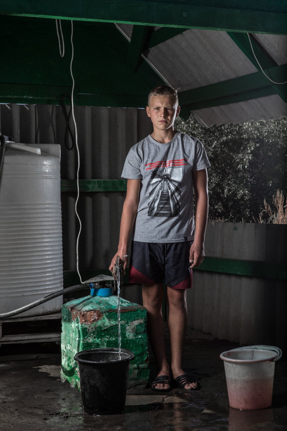 Edik Gorbulin, de 13 aÃ±os, llena un cubo con agua en Bakhmutka, en la regiÃ³n de Donetsk (Ucrania). Edik vive con sus padres y su hermana Elizaveta. La escuela en la que estudiaba fue destrozada por un bombardeo. âNo hay otros chicos con quien jugarâ, dice. âYa no es lo mismo. Antes habÃ­a otros seis chavales que vivÃ­an en mi bloque, pero se fueron todos en 2014â. Ahora ocupa parte de su tiempo ayudando a su madre y su hermana con la colecciÃ³n de agua. âMe siento cansado, pero tengo que ir al pozo a por el agua. Es un trabajo duro para mi madreâ, dice.