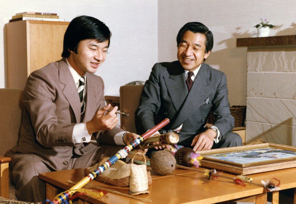 El emperador, aunque sin poder polÃtico, mantiene múltiples funciones como jefe de Estado en Japón: desde los rituales de año nuevo hasta presidir las oraciones sintoÃstas, pasando por ejercer de anfitrión ante las visitas de Estado o participar en algunos actos en el Parlamento nipón. En la fotografÃa, el entonces prÃncipe heredero Akihito y su hijo, el prÃncipe Naruhito, mientras observan varias piezas de artesanÃa de Brasil en el palacio Togu de Tokio, en diciembre de 1982.