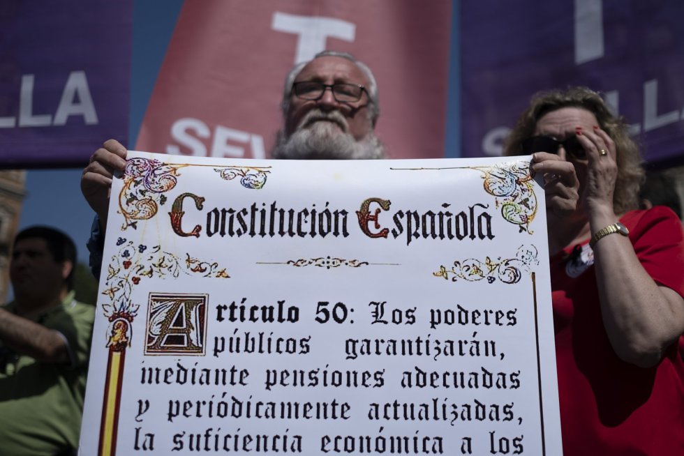En Sevilla, el ambiente festivo y el calor tambiÃ©n han marcado la manifestaciÃ³n, convocada por UGT y CC OO. En la imagen, un hombre sostiene un cartel de la ConstituciÃ³n EspaÃ±ola durante la marcha.