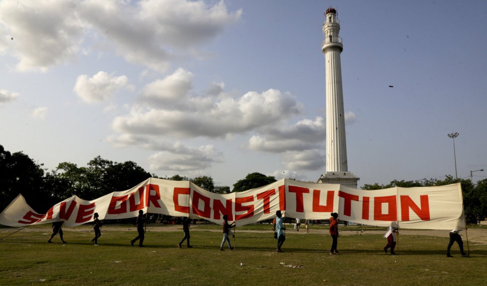 Miembros de los sindicatos de izquierdas caminan con una pancarta que lee "salva nuestra constituciÃ³n" frente al monumento de la ciudad, Shaheed Minar, antes conocido como el Monumento Ochterlony, durante un mitin el 1 de mayo en Calcuta (India).