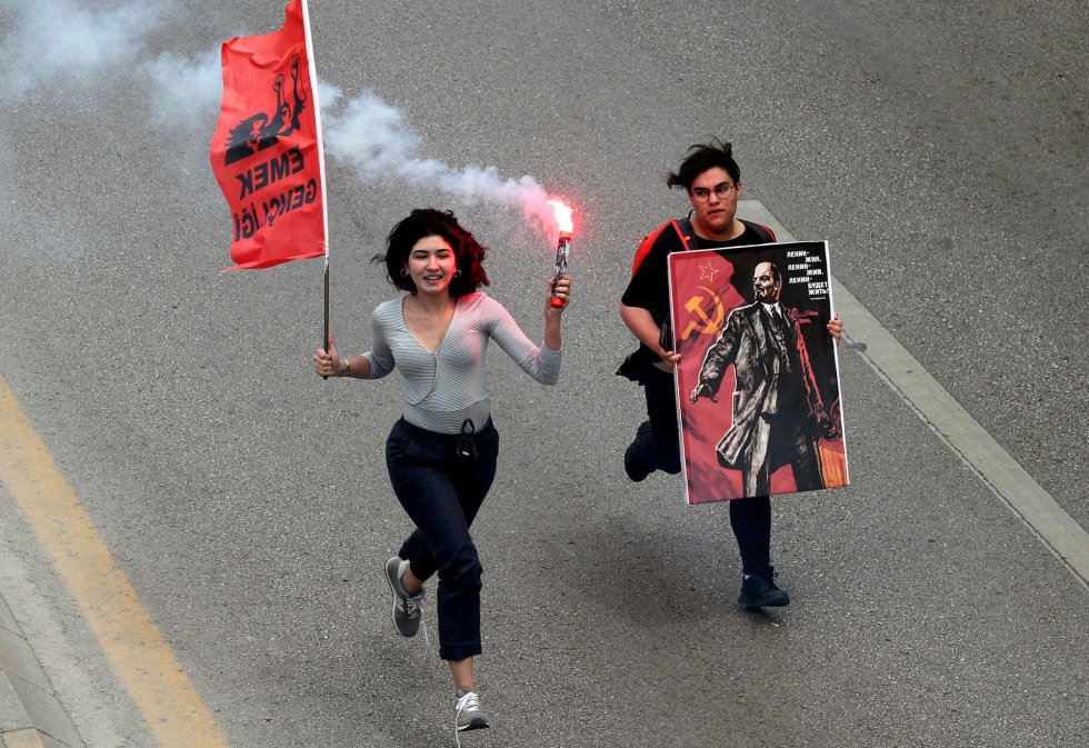 Dos mujeres corren por una calle de Ankara (TurquÃ­a) durante las protestas del 1 de mayo. 
