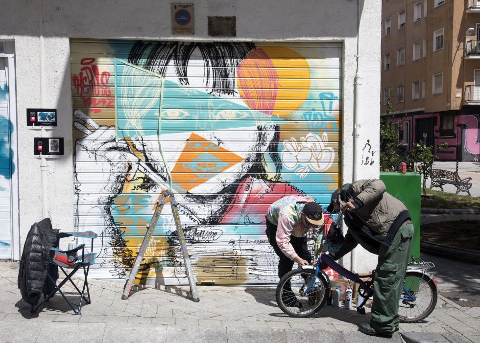 -¿Me pintas la bici? -le pregunta un vecino al grafitero Ãlvaro Hernández, Keru. -Como te la pinte entera vas a parecer galáctico -le responde con un espray rosa en la mano-. Anda, dale pedales para que se seque. -Qué guapa ha quedado, hermano. -Y alza el puño a la altura del pecho y lo choca en horizontal con el de Keru para despedirse. Keru es de Carabanchel, Madrid, y forma parte del colectivo El Keller. Ha pintado una niña china que come fideos. La riqueza de la diversidad es un alegato en favor de la inmigración. "A la gente le mola esta comida pero no los extranjeros que la han traÃdo", denuncia.