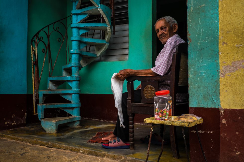 Miguel Calzada, de 90 aÃ±os, delante de su casa en Trinidad, un municipio del centro de Cuba conocido por su casco antiguo de estilo colonial y sus calles adoquinadas. Desde la puerta de su vivienda vende dulces y galletas para complementar su pensiÃ³n.