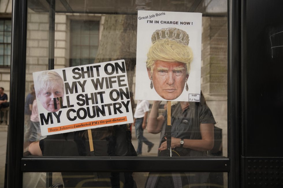 En la imagen, carteles con las imágenes de Boris Johnson y Donald Trump en una parada de autobús de Londres.
