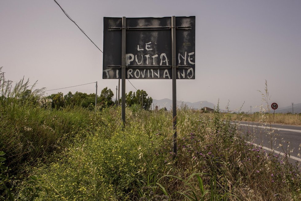 El eslogan "Las prostitutas son tu ruina" en una señal de tráfico de una carretera cercana a Castelvolturno. 