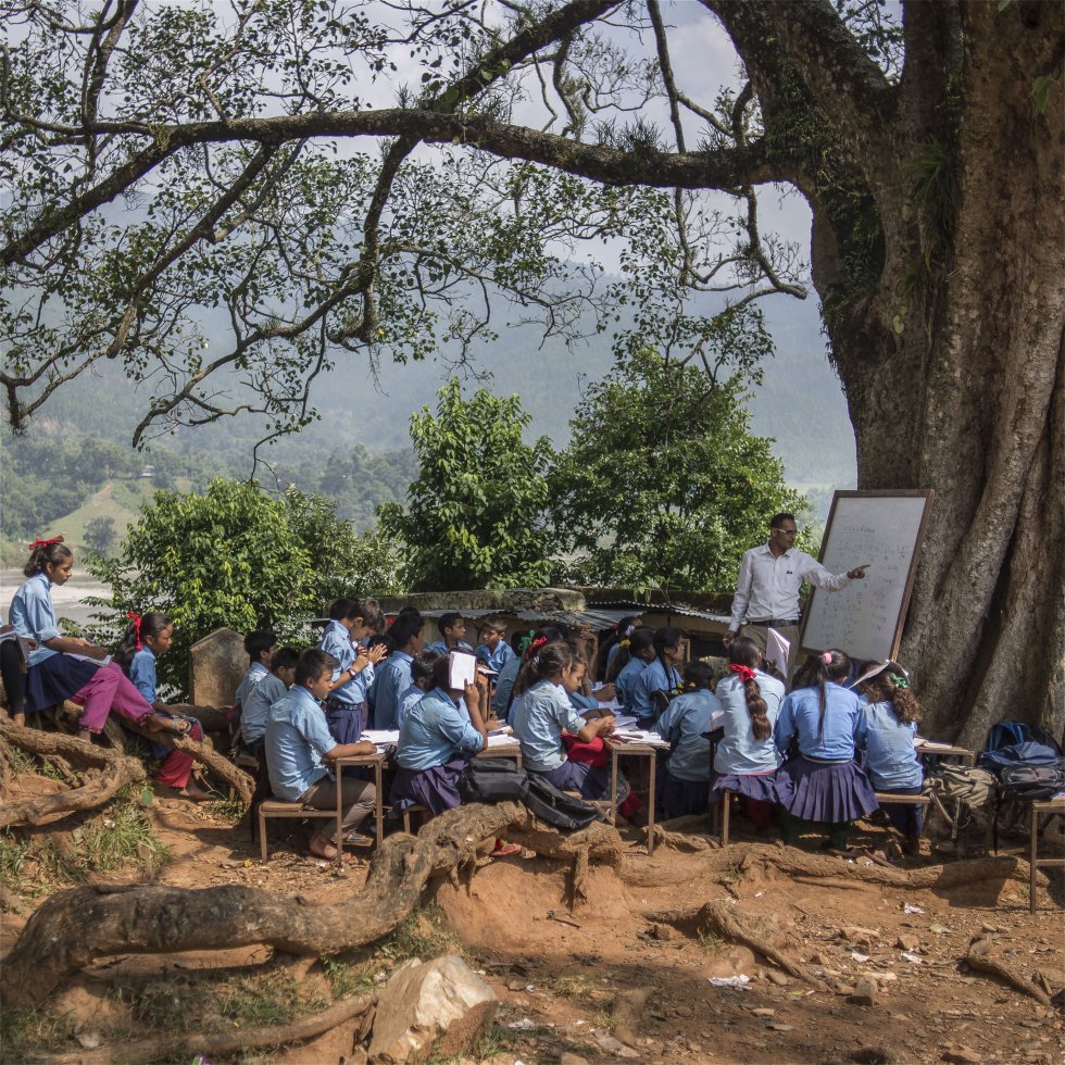Todos los niños y niñas merecen la oportunidad de aprender. Sin embargo, 260 millones de niños y niñas en edad escolar no asisten regularmente al colegio. En lugares como Nepal, los profesores buscan cualquier sitio para poder impartir sus clases. En la imagen, un profesor se dirige a sus alumnos en un aula improvisada en Nepal.