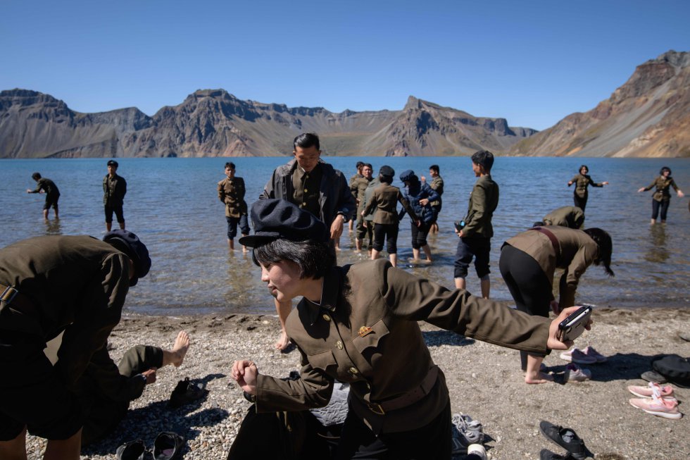 Estudantes norte-coreanos no Lago Chonji, ou 'Lago do Céu', enquanto visitam a cratera do Monte Baekdu. A montanha é a mais alta da cordilheira de Changbai, no norte, e Baekdugaegan, no sul.
