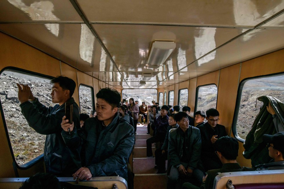 De acordo com Ri Yong Myong, estudante de literatura coreana na Universidade Kim Il-Sung em Pyongyang, os norte-coreanos veem mais do que honra e riqueza no Monte Baekdu. "Todo mundo precisa de pilares espirituais", e é assim que a montanha é vista de acordo com Ri Yong Myong, 30, que também esteve alistado no exército por 10 anos. Na foto, os alunos usam seus telefones celulares para tirar fotos durante a viagem ao topo do Monte Baekdu.