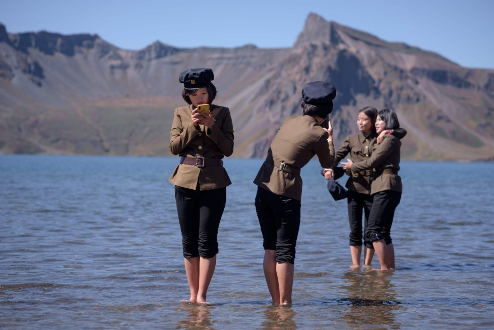 Estudantes norte-coreanos tiram fotos no 'Lago do Céu' durante sua visita ao Monte Baekdu. Segundo o guia, esse acampamento secreto foi desde 1936 a base onde Kim Il-Sung organizou a resistência que "finalmente alcançou a libertação histórica do país".