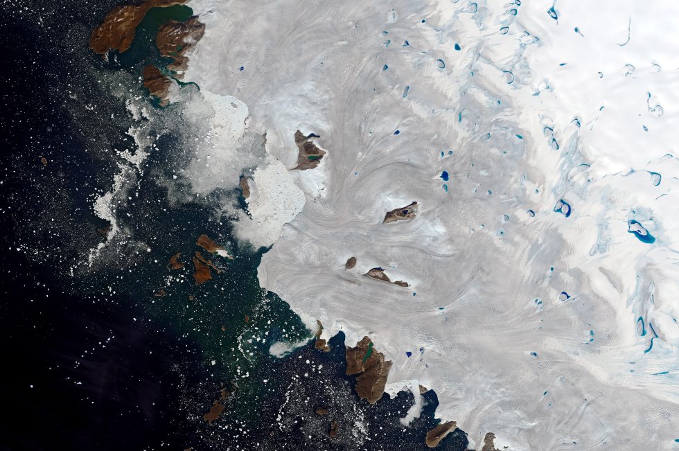 Una imagen satelital de la NASA muestra el estanque de agua de deshielo en el noroeste de Groenlandia, el 30 de julio de 2019. Miles de millones de toneladas de agua de deshielo fluyeron hacia el Océano Atlántico durante todo el mes de julio de este año, haciendo una contribución directa e inmediata al aumento del nivel del mar.