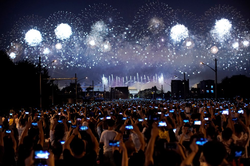 Personas fotografían y graban los fuegos artificiales durante la gala nocturna que conmemora el 70 aniversario de la fundación de la República Popular de China, en su Día Nacional en Beijing.