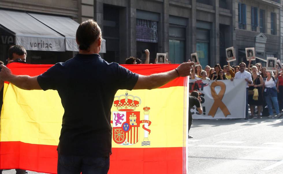 Un hombre con una bandera de España se encara con los centenares de personas que cortan la céntrica Via Laietana de Barcelona, este lunes.