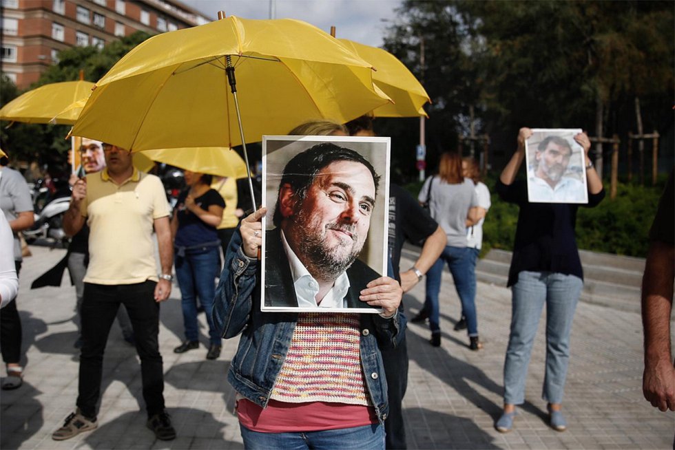 Un manifestante en una concentración en Barcelona porta una bandera con la imagen de Oriol Junqueras, este lunes.