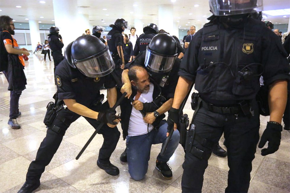 Los Mossos actúan en el aeropuerto de El Prat ante las protestas por la sentencia del procés. Los Mossos han inmovilizado a un hombre en el suelo del acceso al metro de la Terminal 1 de El Prat. "Me hacéis daño", grita. 