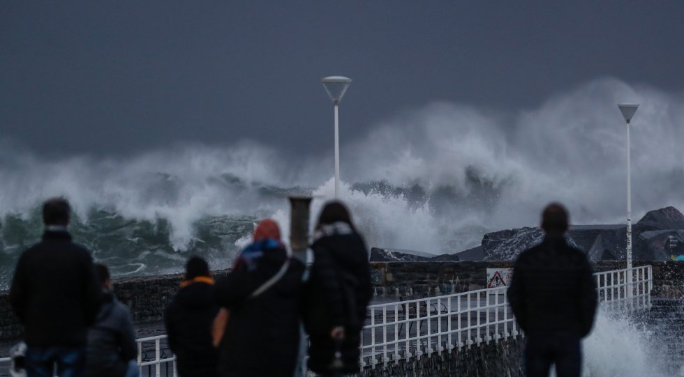 Un grupo de personas observa el fuerte oleaje que rompe contra el espigón de la playa de la Zurriola de San Sebastián, el 14 de noviembre.