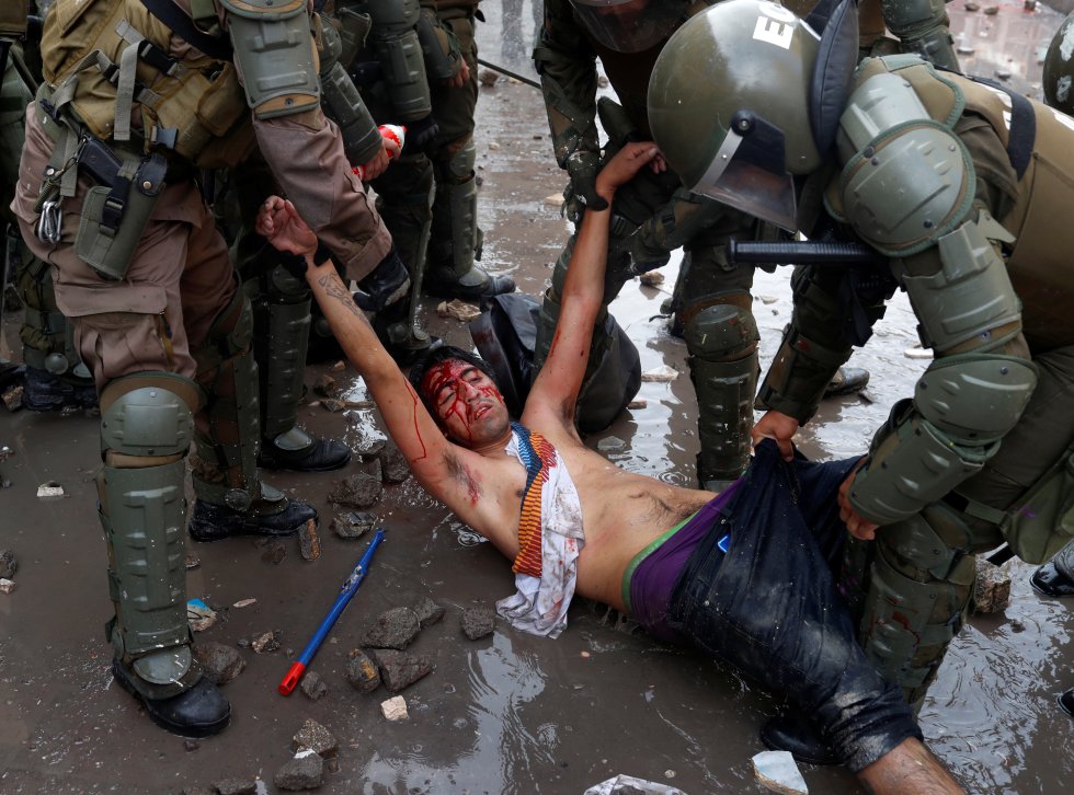 Un hombre herido es detenido por las fuerzas de seguridad en una protesta contra el Gobierno en Santiago de Chile, el 14 de noviembre de 2019. La crisis política y social en Chile comenzó con la subida del precio del metro y se convirtió en un estallido contra las desigualdades sociales.