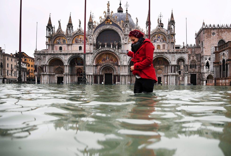 Una mujer cruza la Plaza de San Marcos en Venecia. La ciudad de la laguna fue inundada por una excepcional 'acqua alta', una subida insólita de los niveles de la marea, el 13 de noviembre.
