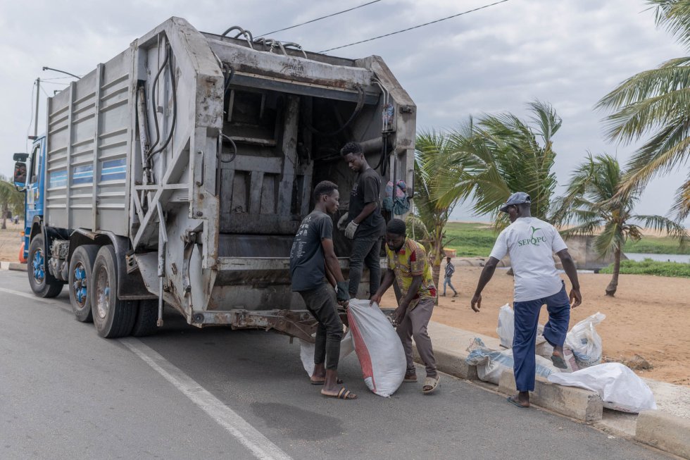 Operarios del ayuntamiento recogen los desechos retirados por los miembros de ERD Afrique. El consistorio de Lomé apoya logísticamente las actividades de limpieza. Una vez los voluntarios de la asociación los junta, un camión municipal los lleva a un vertedero.
