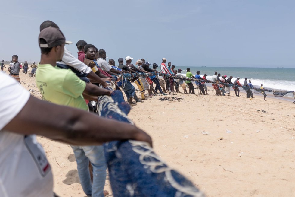 Pescadores extrayendo una red en la playa de Lomé. Entre 20 y 30 personas tardan una media de tres horas en sacarla del mar. Los patrones o dueños de las redes, se quejan que después de repartir la captura entre los pescadores, los beneficios que quedan son mínimos.