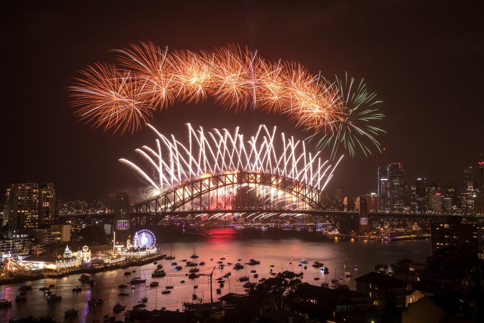 Los fuegos artificiales iluminan el cielo sobre el puerto de Sídney (Australia) durante las celebraciones de Nochevieja.