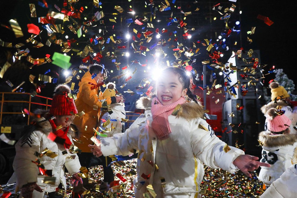 Una niña celebra durante el conteo por la llegada el nuevo año en el parque Shougang en Beijing, China.