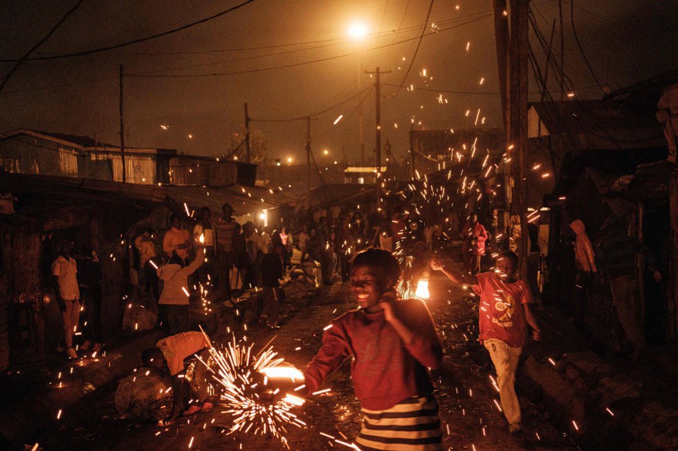 Varios niños juegan con luces de bengala durante los festejos en Nairobi.
