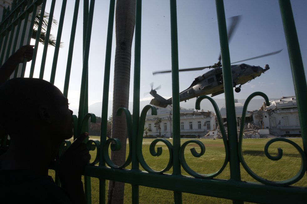 Esta foi a foto de capa do EL PAÍS em 20 de janeiro. O título dizia: "Tropas dos EUA assumem o controle para garantir ajuda". A imagem incluía o momento em que um helicóptero pousou nos jardins do palácio presidencial haitiano destruído. Após a chegada, as tropas americanas assumiram o controle do porto e do aeroporto para garantir a distribuição da ajuda humanitária.