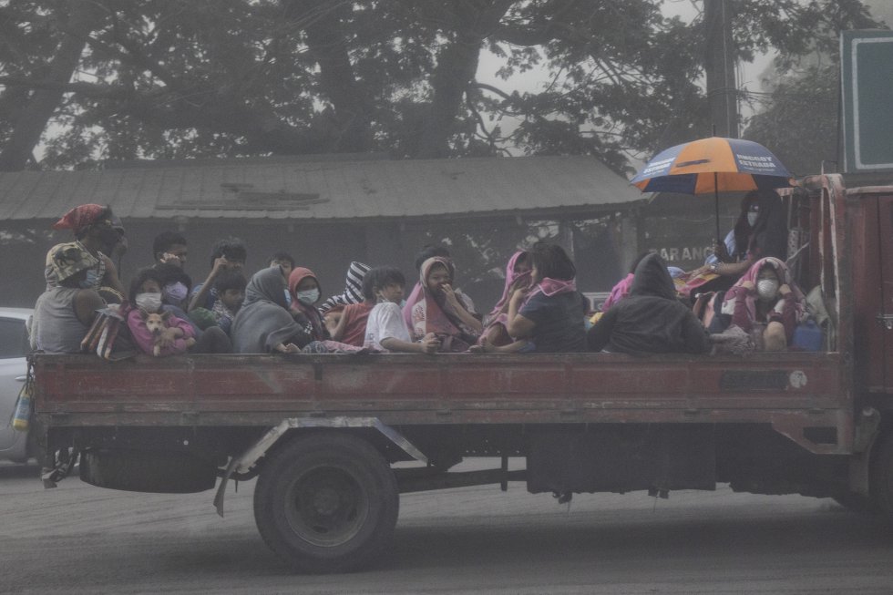 Los residentes huyen de la erupción del volcán Taal en un camión de plataforma el 13 de enero, en Lemery, provincia de Batangas (Filipinas). 